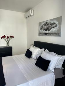 um quarto com uma cama branca com almofadas pretas e brancas em Stunning apartment Josipa em Kaštela