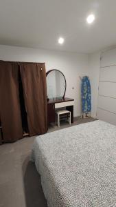 una camera con letto, scrivania e specchio di Joli appartement F2 entièrement rénové a Sélestat