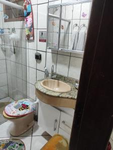 uma casa de banho com um lavatório, um WC e um espelho. em Suíte independente a 10 minutos da praia em Vila Velha