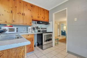 Una cocina con gabinetes de madera y un horno de estufa. en Gem by The Beach Unit B Walk to Beach, Shops, Bars, en Tybee Island