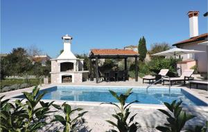 a swimming pool with a gazebo next to a house at Holiday Home Barban 60 in Barban