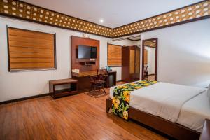 a bedroom with a bed and a desk and a kitchen at Club Agutaya in San Vicente