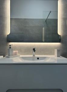 uma casa de banho com um lavatório e um espelho em Stunning apartment Josipa em Kaštela