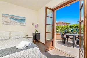 a bedroom with a bed and a table and a balcony at Hotel la Pietra restaurant in Fosdinovo