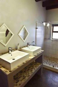 a bathroom with two sinks and a shower at Hemel op Aarde Villa in Dwarskersbos