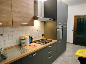 Henson appartamento في تورتونا: مطبخ مع موقد فرن علوي بجوار حوض