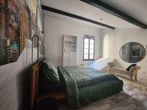 1 dormitorio con cama verde y espejo en L'Elégant, en Montauban