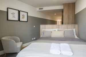 a bedroom with a large bed and a chair at Apto Ribeira Lisboa in Lisbon