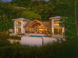 una casa con una piscina di fronte di Casa Frenchie - by Pura Villas a Dominicalito