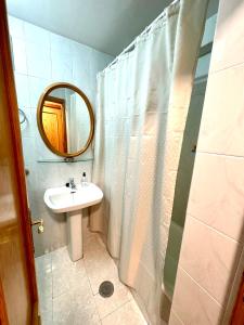 a bathroom with a sink and a shower with a mirror at Esquí y Relax Apartamento in Sierra Nevada