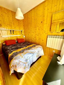 um quarto com uma cama numa parede de madeira em Esquí y Relax Apartamento em Sierra Nevada