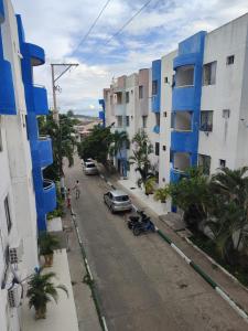 a street with blue buildings and a car parked on the street at Mirador de zaragocilla in Cartagena de Indias