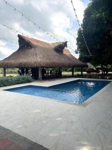 uma grande cabana com uma piscina com telhado de palha em Hermosa cabaña la Promesa en Malambo. em Malambo