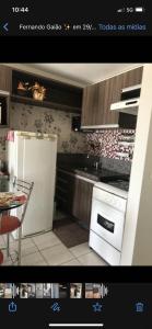 a kitchen with a white refrigerator and a table at Personal Residence in João Pessoa