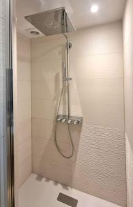 La salle de bains est pourvue d'une douche avec une porte en verre. dans l'établissement Luxury flat with amazing view on Eiffel Tower, à Paris