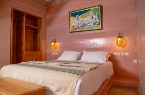 a bedroom with a large bed with pink walls at Palais Riad Hida in Oulad Barrehil