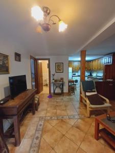 sala de estar con TV, sofá y mesa en El Portal del Abuelo, en Arenas de Cabrales