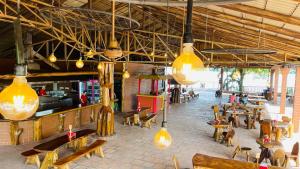 un restaurante con mesas, sillas y luces en Hotel Tekal del Rio en Puerto Boyacá