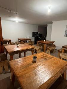 a large room with wooden tables and a kitchen at Hostal Lodge Wine Colchagua in Nancagua