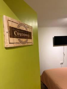 ein Schlafzimmer mit einer grünen Wand mit einem Schild, das Chocobo liest in der Unterkunft Hostal Lodge Wine Colchagua in Nancagua