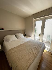 a bedroom with a large bed and a large window at Alto Las Condes Apartments in Santiago