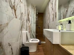 La salle de bains est pourvue de toilettes blanches et d'un lavabo. dans l'établissement T&T - Luxury apartments, à Athènes