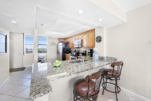 a kitchen with a counter and two bar stools at South Seas Tower 3-905 in Marco Island