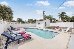 - une piscine avec 2 chaises bleues et une table dans l'établissement 320 Marco Lake Drive, à Marco Island