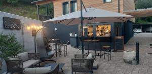 un patio con sillas y un bar con sombrilla en Albergo Ristorante Fratte, en Fregona