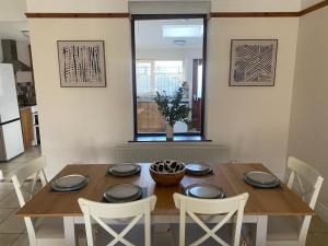 a dining room table with white chairs around it at Harbour Views 3 Bed Townhouse with private off street parking and office in Portstewart