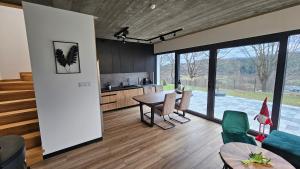 a kitchen and living room with a table and chairs at Tarnova Chill in Tarnawa