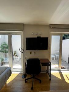 1 dormitorio con escritorio y TV de pantalla plana en Alto Las Condes Apartments, en Santiago