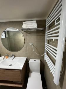 a bathroom with a sink and a toilet and a mirror at Alto Las Condes Apartments in Santiago