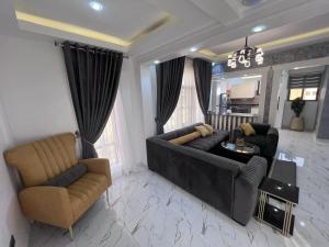 sala de estar con sofá y 2 sillas en Panafest Two Block - 3Fingers, en Accra