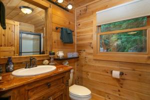 a bathroom with a sink and a toilet in a cabin at Dreamy Mountain Getaway~Hot Tub~Old Oak Lodge in Waynesville +33 photos