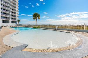 a swimming pool with a fountain in front of a building at Lighthouse in Gulf Shores