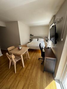 a bedroom with a bed and a desk and a table at Alto Las Condes Apartments in Santiago