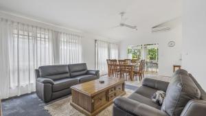 a living room with two couches and a table at Tranquil At Hibbard - 21 Hibbard Drive in Port Macquarie