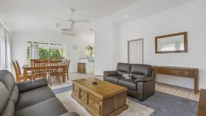 a living room with a couch and a table at Tranquil At Hibbard - 21 Hibbard Drive in Port Macquarie