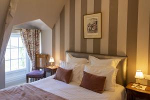 a bedroom with a bed with a striped wall at Hostellerie de la Motte jean in Saint-Coulomb