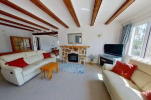 uma sala de estar com mobiliário branco e uma lareira em Entire home in Jávea-view Montgo em Xàbia