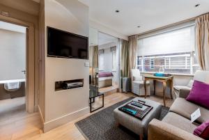a living room with a couch and a tv at Nell Gwynn House Apartments & Rooms in London