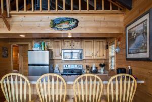 eine Küche mit einer Theke mit Stühlen und einem Kühlschrank in der Unterkunft Deer Island in Bigfork