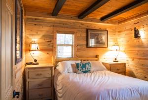 ein Schlafzimmer mit einem Bett in einer Holzhütte in der Unterkunft Deer Island in Bigfork