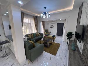 uma sala de estar com sofás e um lustre em Panafest Two Block - 3Fingers em Acra