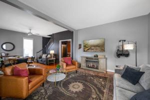 een woonkamer met meubilair en een open haard bij Elegant House 2 min from BSU/Hospital/Downtown in Muncie