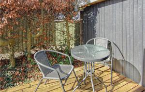 two chairs and a table on a wooden deck at Holiday Home Binderup Strandpark Bjert Denmark in Sønder Bjert
