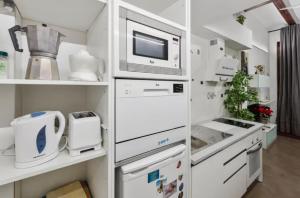 a kitchen with white appliances and a microwave at La Casita de la Reina in Valencia +1 photo