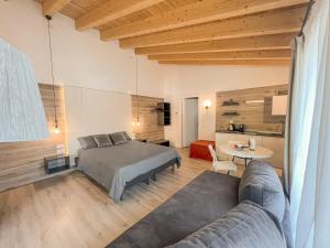 a bedroom with a bed and a couch and a table at Albergo Ristorante Fratte in Fregona