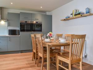 a kitchen and dining room with a wooden table and chairs at Burrows Ridge in Appledore